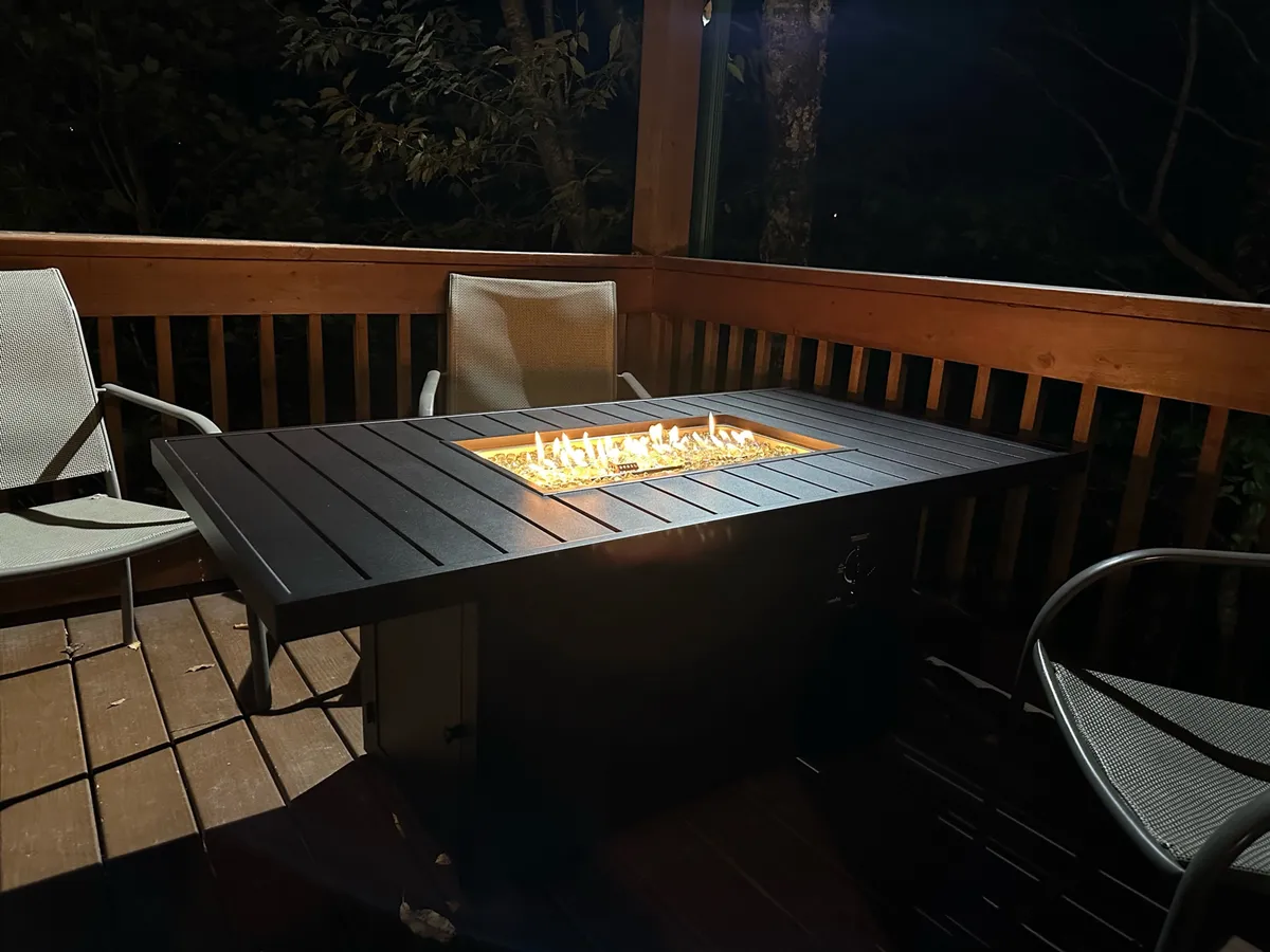 A cozy outdoor fire pit sits on a wooden deck surrounded by comfortable seating, creating a warm and intimate atmosphere ideal for evening relaxation and stargazing.